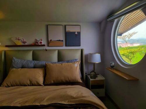 a bedroom with a bed and a window at Adachi Farmstay Bảo Lộc in Bao Loc