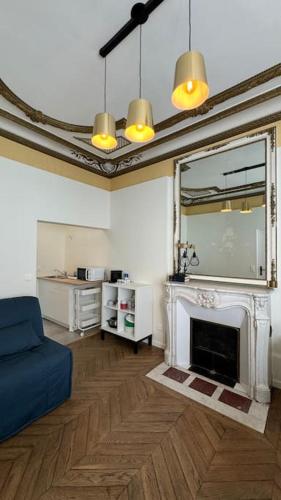 un salon avec un canapé bleu et une cheminée dans l'établissement Studio 89 Albufera - Gare Vernon Giverny, à Vernon