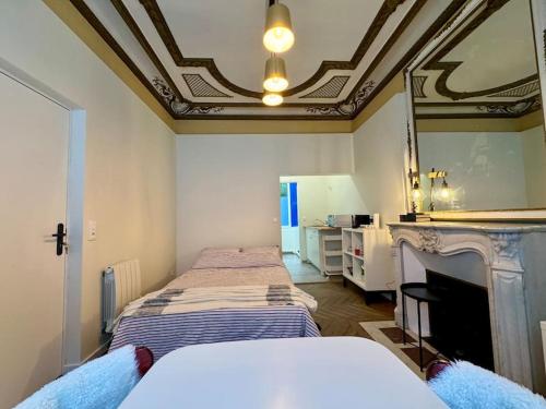 une chambre avec deux lits avec un miroir et une cheminée dans l'établissement Studio 89 Albufera - Gare Vernon Giverny, à Vernon