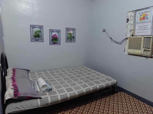 a room with a bed with a phone and pictures on the wall at Meljunaire Staycation in Trece Martires
