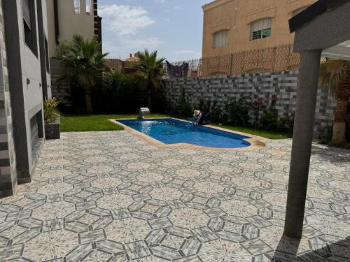 a patio with a swimming pool in a yard at Villa avec piscine oujda CGI in Oujda