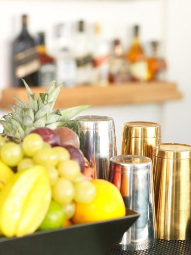a bowl of fruit on a table with glasses at San Marino Suites by Calm Collection in Fira