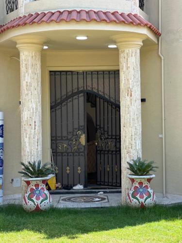 an entrance to a house with a black gate at Relaxing Villa with private pool in King Mariout