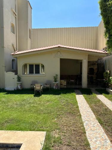 a house with a grass yard in front of it at Relaxing Villa with private pool in King Mariout
