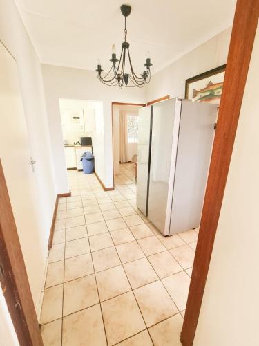 a kitchen with a refrigerator and a tile floor at Syringa Sea View in Pennington