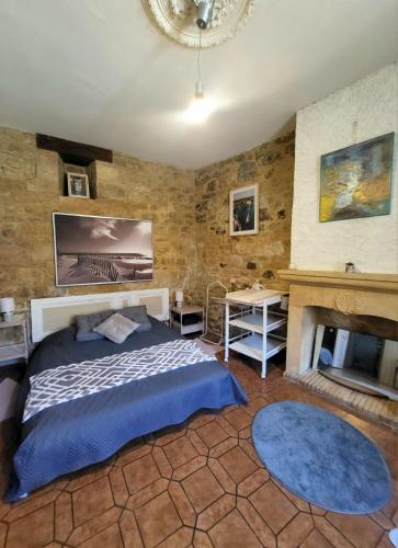 une chambre avec un lit et une cheminée dans l'établissement Gite de la Marquise, Maison périgourdine de charme, en pierre, à 2min à pieds de la cité médiévale de Sarlat, à Sarlat-la-Canéda