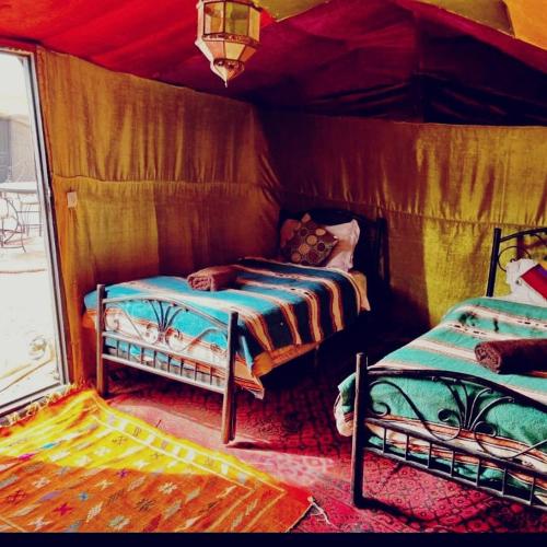 a room with two beds in a tent at Overnight Desert Camp in Merzouga