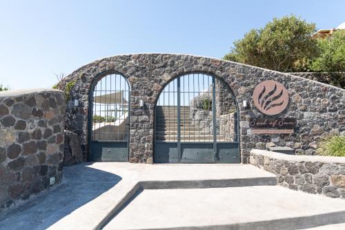 an entrance to a stone building with two gates at Soil of Sun Luxury Villas in Megalokhori