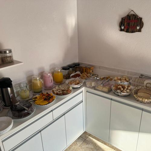a counter with many plates of food and orange juice at Pousada Recanto da Luísa in Paraty