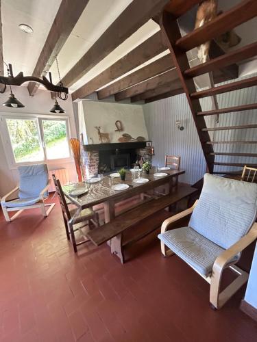 ein Wohnzimmer mit einem Holztisch und Stühlen in der Unterkunft Chalet de montagnes in Campan