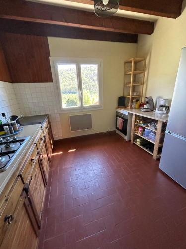 an empty kitchen with a refrigerator and a window at Chalet de montagnes in Campan