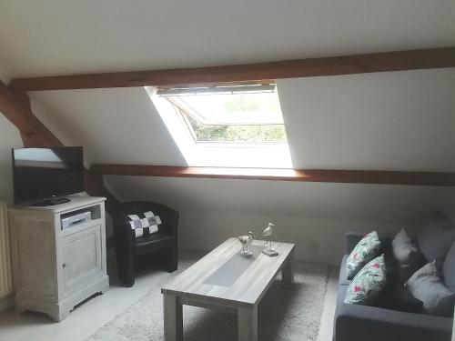 sala de estar con tragaluz, sofá y mesa en la maison de Marie, en Beaumont-les-Autels