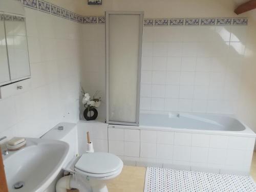 Un baño con bañera, inodoro y lavabo. en la maison de Marie, en Beaumont-les-Autels