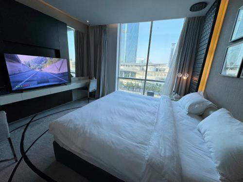 a hotel room with a bed and a flat screen tv at DAMAC Towers Riyadh by SELSAL داماك الرياض in Riyadh