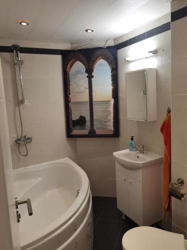 a bathroom with a tub and a toilet and a sink at VILLA METATRON U DOMA in Balchik