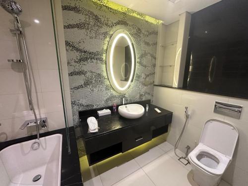 a bathroom with a sink and a toilet and a mirror at DAMAC Towers Riyadh by SELSAL داماك الرياض in Riyadh