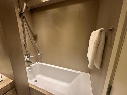 a white bath tub in a bathroom with a towel at DAMAC Towers Riyadh by SELSAL داماك الرياض in Riyadh