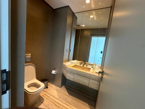 a bathroom with a toilet and a sink and a mirror at DAMAC Towers Riyadh by SELSAL داماك الرياض in Riyadh