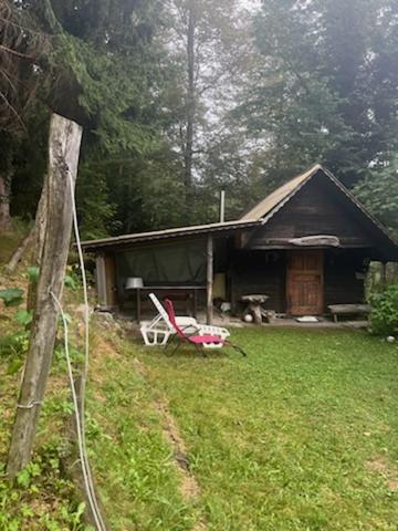 une maison dotée d'une cour avec une chaise en face dans l'établissement Lisičja bajta, à Stahovica