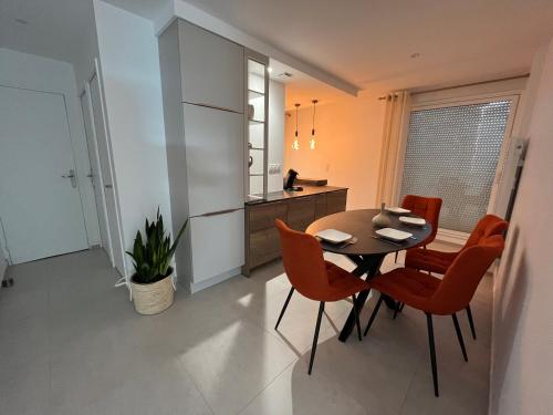 une cuisine et une salle à manger avec une table et des chaises dans l'établissement Magnifique appartement pour 4 personnes face à la mer, à Saint-Gilles-Croix-de-Vie