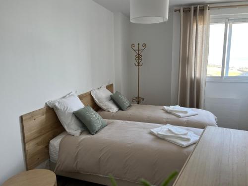 une chambre d'hôtel avec deux lits et une table dans l'établissement Magnifique appartement pour 4 personnes face à la mer, à Saint-Gilles-Croix-de-Vie