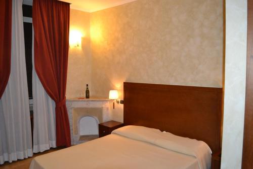 una camera d'albergo con letto e camino di Dipendenza Hotel Galileo a Roma