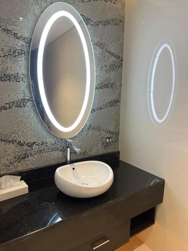 a bathroom with a sink and a mirror on a counter at DAMAC Towers Riyadh by SELSAL داماك الرياض in Riyadh