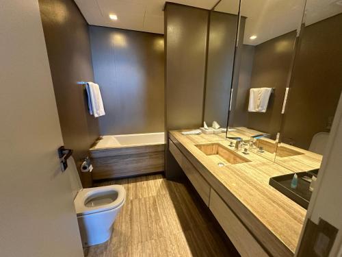 a bathroom with a toilet and a sink and a tub at DAMAC Towers Riyadh by SELSAL داماك الرياض in Riyadh