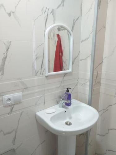 a white bathroom with a sink and a mirror at Дом где есть всё удобства 2 in Khashuri