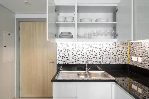 a kitchen with a sink and white cabinets at Aykon City 2 bedroom Burj view in Dubai