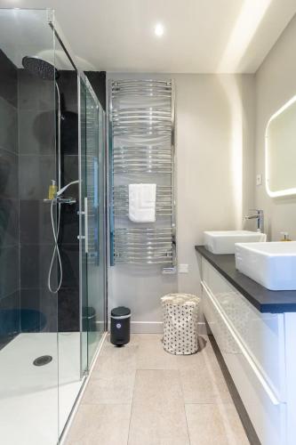 une salle de bain avec une douche en verre et un lavabo dans l'établissement Le Puits de Lumière, à Honfleur