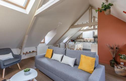 - un salon avec un canapé bleu et des oreillers jaunes dans l'établissement Le Puits de Lumière, à Honfleur