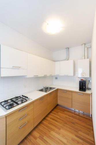 a kitchen with white cabinets and a stove top oven at Residence Theresia- Tailor Made Stay in Trieste