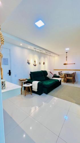 a living room with a green couch and a table at Arraial Praia Ap - Residence Club Praia dos Anjos in Arraial do Cabo
