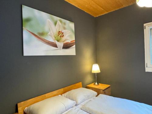 a bedroom with a bed and a painting on the wall at Between Lakes Beatenberg in Beatenberg