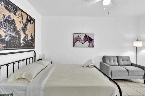 a white bedroom with a bed and a chair at Downtown Hollywood Beach Blvd Studio Getaway in Hollywood