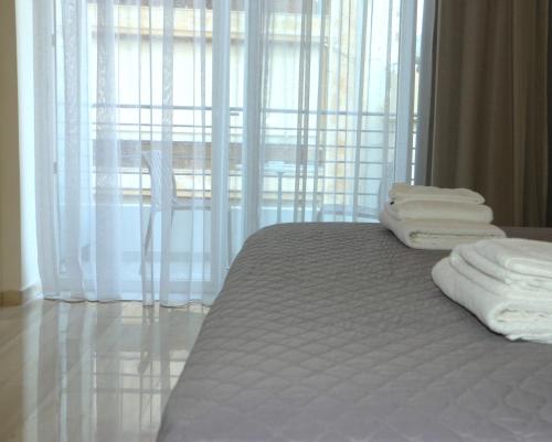 a bed with white towels sitting on top of it at Piraeus Relax in Piraeus