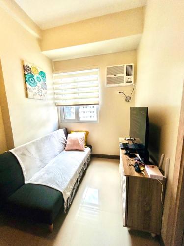 a bedroom with a bed and a desk with a computer at Urban Oasis 2BR Condo with Multiple Pools at SMDC Charm Residences in Manila
