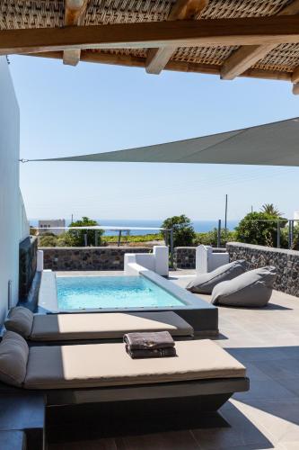 an outdoor pool with chaise lounge chairs and a swimming pool at Soil of Sun Luxury Villas in Megalokhori
