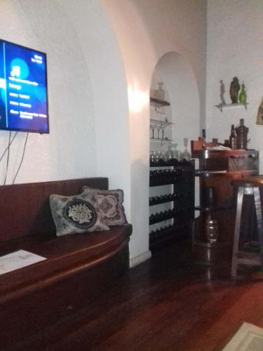 a living room with a couch and a tv on the wall at Muqui 91 Guesthouse in Teresópolis
