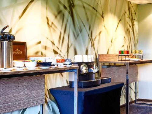 a restaurant with a table with food on it at Novotel Milton Keynes in Milton Keynes