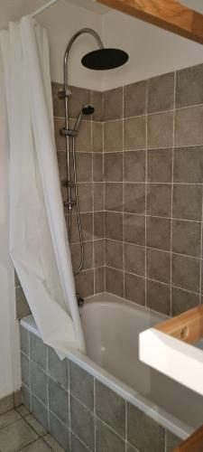 ル・デヴォリュイにあるGrand 3 pièces cosy à SuperDévoluy (05) - Plein Sud, au pied des pistesのバスタブとシャワー付きのバスルーム