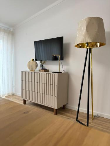 a lamp in a living room with a tv at At Maries Beach House Peniche 2 in Peniche