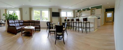 a living room with a couch and a table and chairs at Hotel Falkenhagen in Pritzwalk