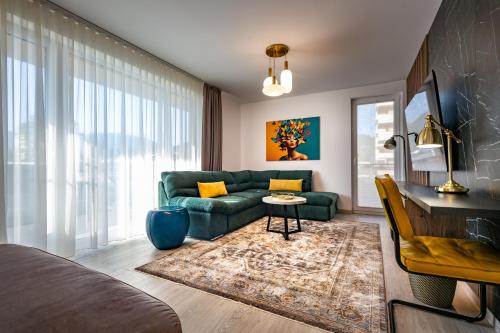 a living room with a green couch and a table at Mountain View Terrace Oasis with Parking and AC in Braşov