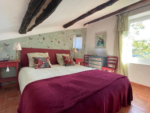 une chambre avec un grand lit avec une couverture violette dans l'établissement Village home in Ménerbes, à Ménerbes