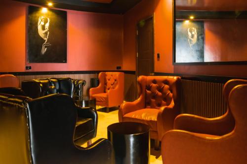 a waiting room with orange chairs and a bar at Avian Court Hotel in Naivasha