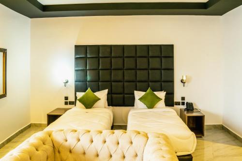 two beds in a room with a couch at Avian Court Hotel in Naivasha