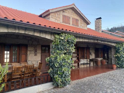 an old house with a porch with chairs and vines at Casa da Ondrinha in Capinha