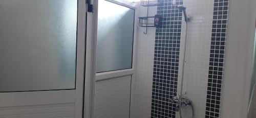 a bathroom with a shower with a glass door at Ground Floor Lovely two bedrooms apartment in Flic-en-Flac